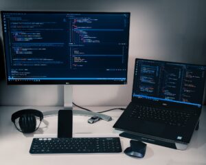 featured image comprising of a desk with a pc and laptop and some other peripherals